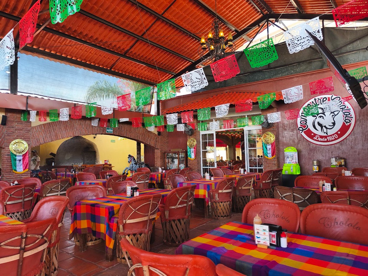 Salón con papel picado y mesas de colores
